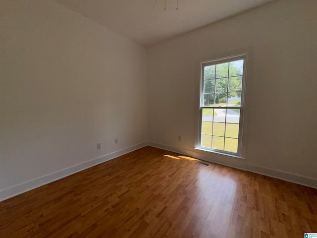 unfurnished room with hardwood / wood-style flooring