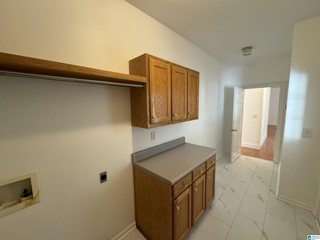 clothes washing area featuring marble finish floor, hookup for an electric dryer, hookup for a washing machine, baseboards, and cabinet space