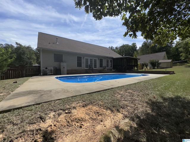 pool featuring french doors, fence, a lawn, a sunroom, and a patio