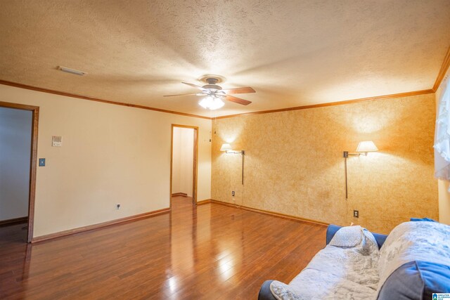 unfurnished living room with ornamental molding, a textured ceiling, wood-type flooring, and ceiling fan