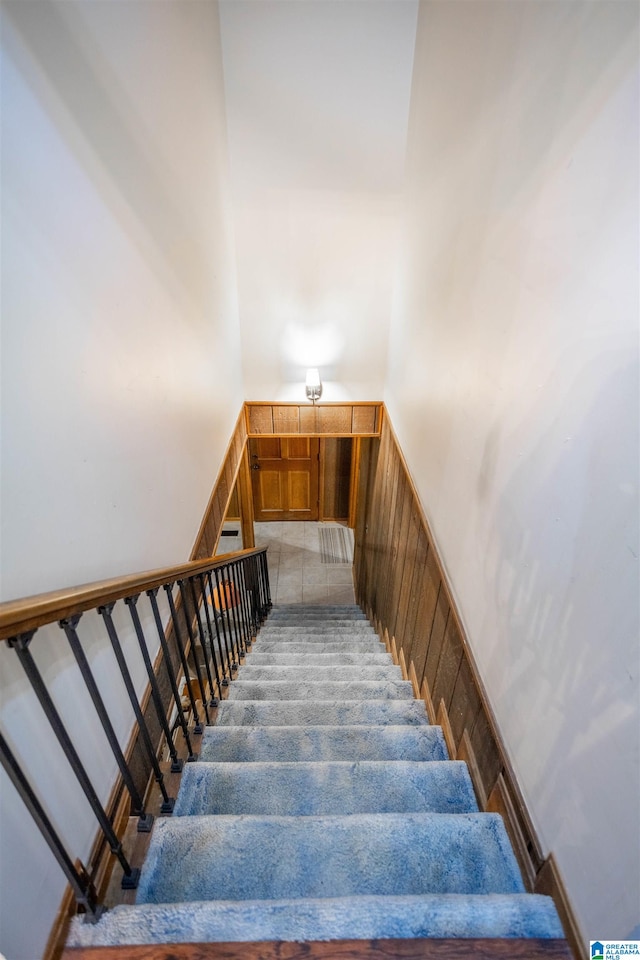 stairway featuring a towering ceiling