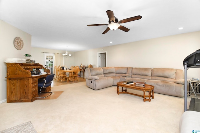 living room with ceiling fan with notable chandelier and light colored carpet