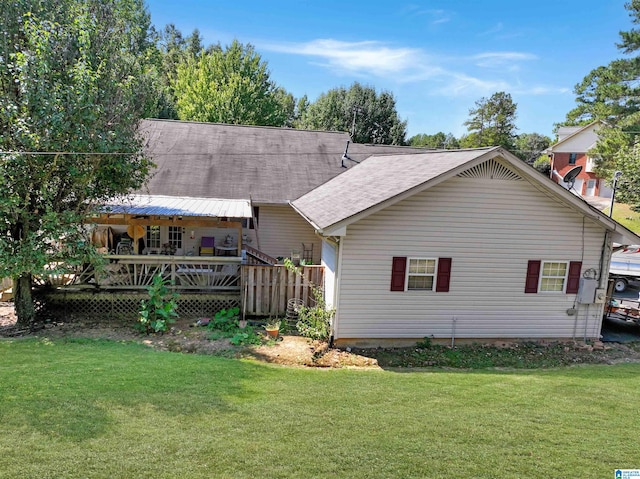 rear view of property featuring a yard and a wooden deck