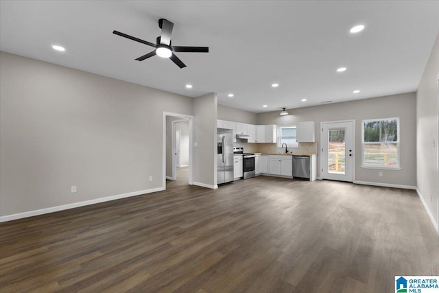 unfurnished living room with dark hardwood / wood-style flooring, ceiling fan, and sink