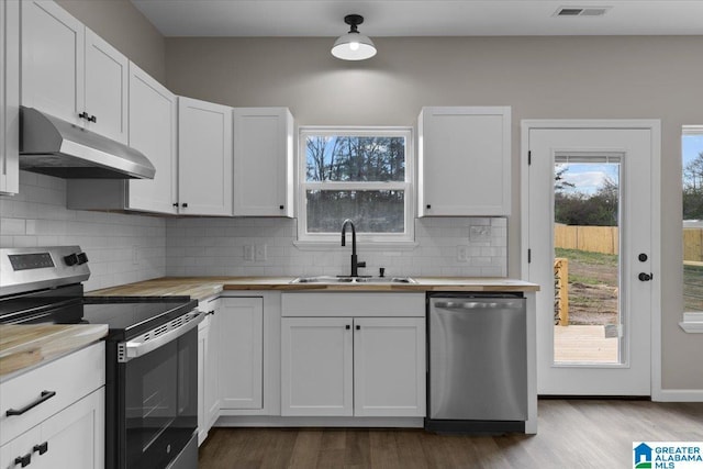 kitchen featuring hardwood / wood-style floors, white cabinets, sink, tasteful backsplash, and stainless steel appliances