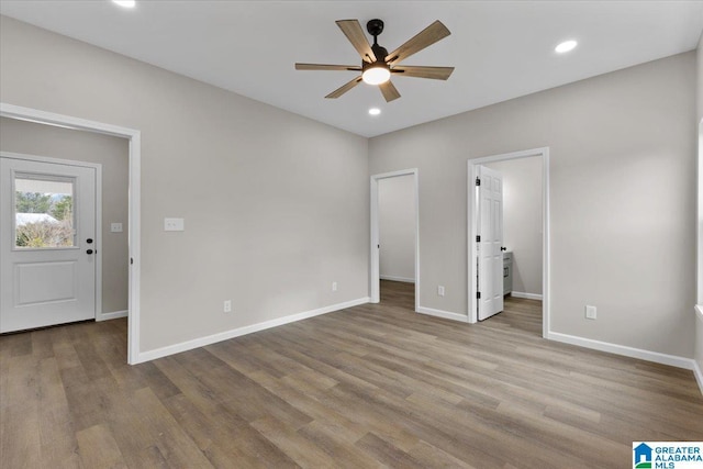 unfurnished bedroom featuring ceiling fan, a walk in closet, connected bathroom, and light hardwood / wood-style flooring