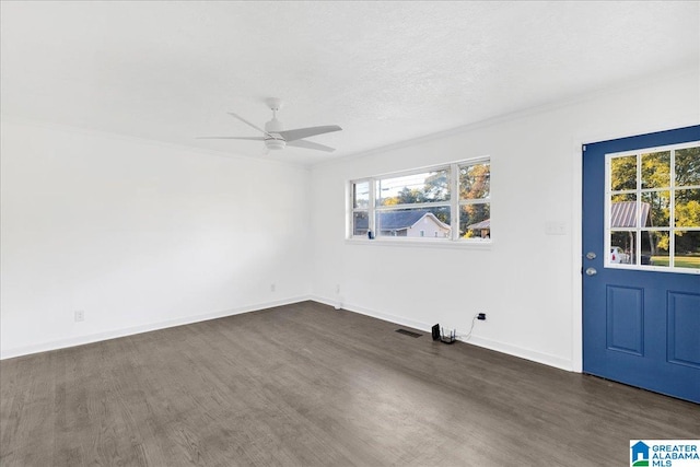 empty room with dark hardwood / wood-style flooring, a textured ceiling, ceiling fan, and crown molding