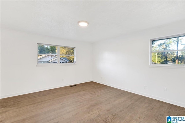 spare room featuring wood-type flooring and a textured ceiling