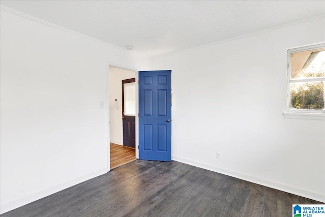 spare room with ornamental molding and dark hardwood / wood-style floors