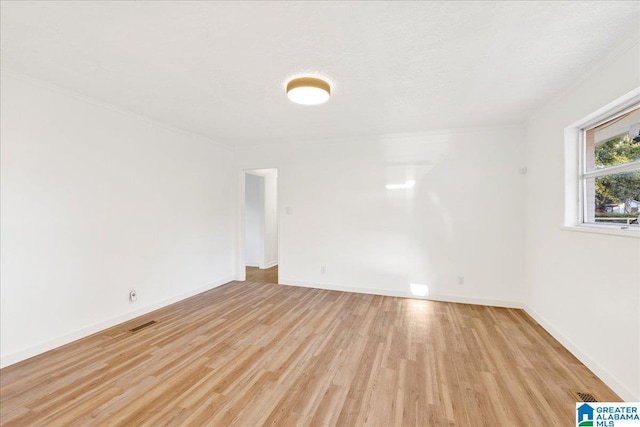 spare room with light wood-type flooring and a textured ceiling