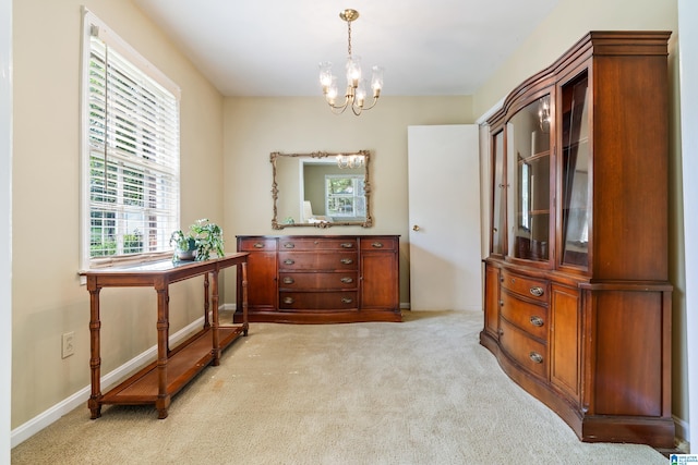 dining room featuring light carpet and a chandelier