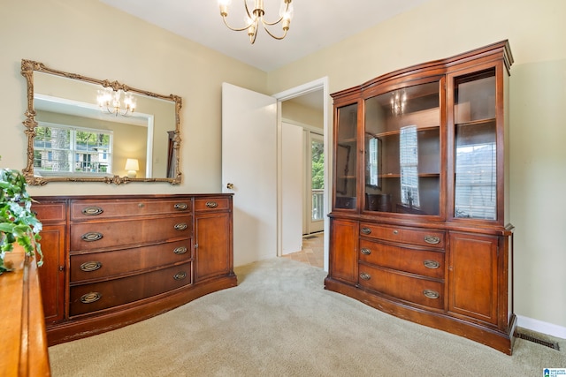 bedroom featuring light carpet and a notable chandelier