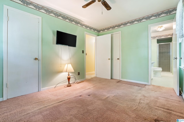 unfurnished bedroom featuring connected bathroom, carpet, and ceiling fan