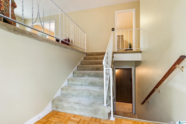 staircase featuring parquet floors