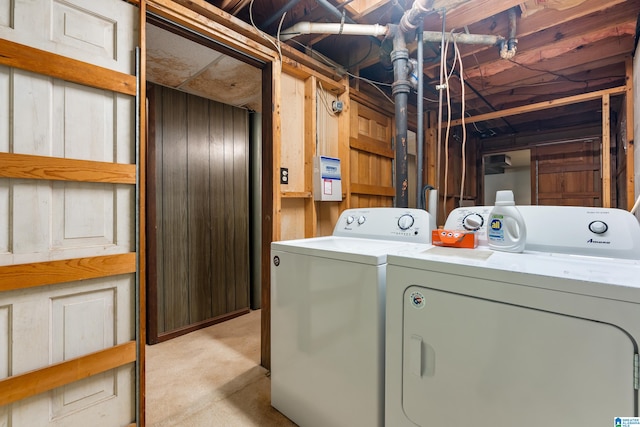 laundry room with wood walls and separate washer and dryer