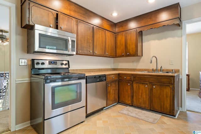 kitchen featuring appliances with stainless steel finishes, sink, and light carpet