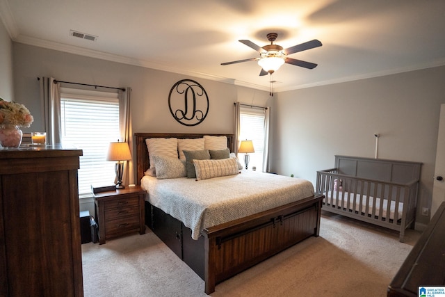 carpeted bedroom featuring ceiling fan and crown molding