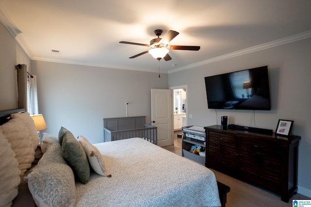 bedroom featuring ceiling fan, ensuite bathroom, and crown molding