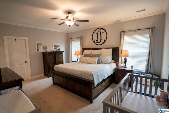 carpeted bedroom with multiple windows, ceiling fan, and ornamental molding