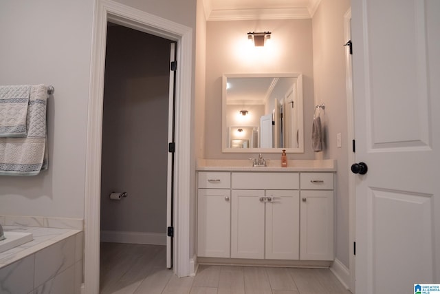 bathroom with vanity, ornamental molding, and a bath