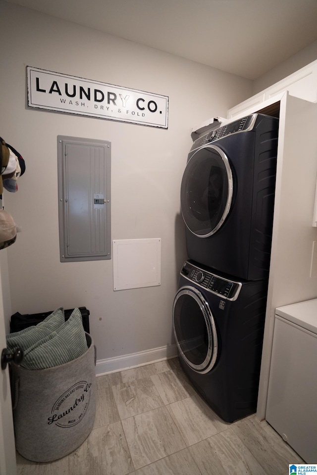 laundry room with electric panel and stacked washer and clothes dryer