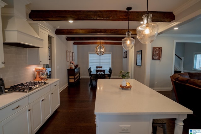 kitchen featuring premium range hood, dark hardwood / wood-style floors, a kitchen island, white cabinetry, and stainless steel gas cooktop