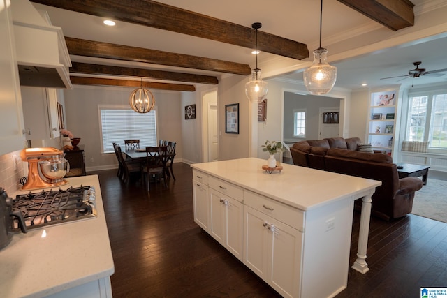 kitchen with a center island, white cabinetry, hanging light fixtures, and a healthy amount of sunlight