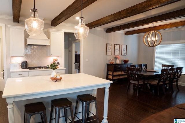 kitchen featuring pendant lighting, an inviting chandelier, white cabinets, tasteful backsplash, and dark hardwood / wood-style flooring