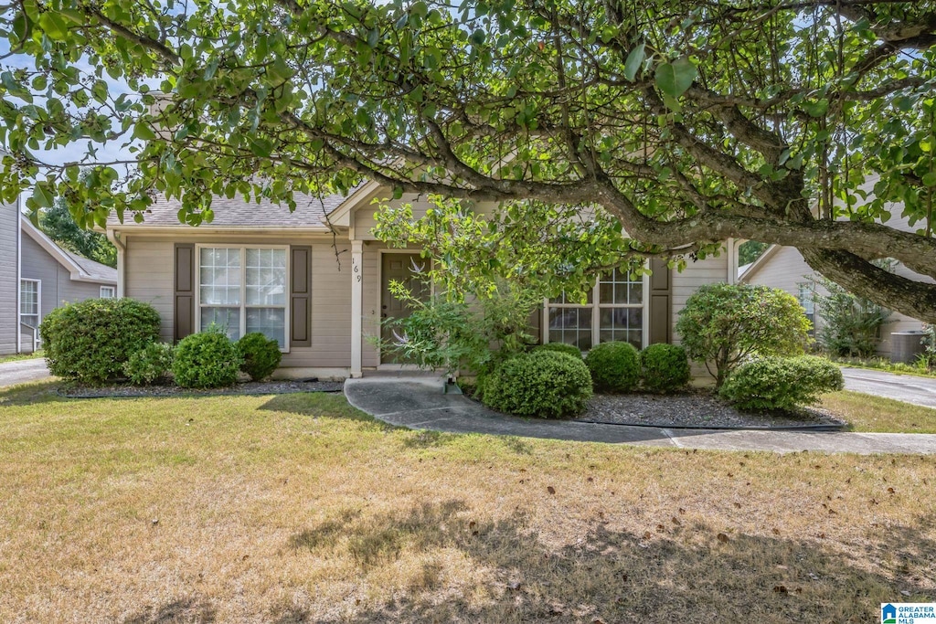 view of property hidden behind natural elements featuring a front yard