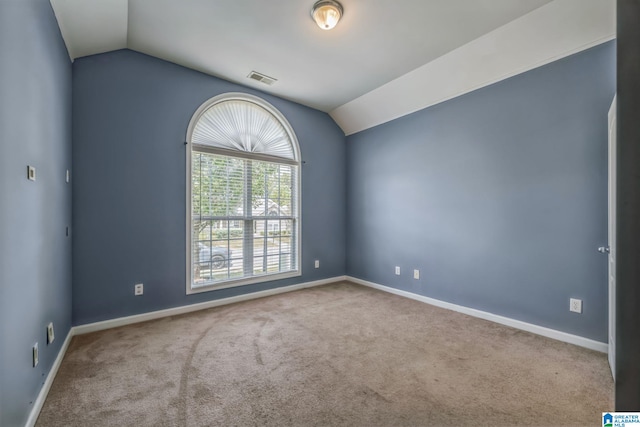 carpeted spare room featuring lofted ceiling