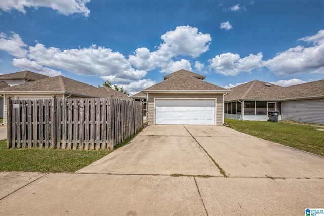 exterior space with a garage, a sunroom, and a front lawn