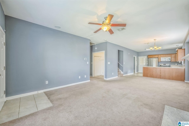 unfurnished living room with ceiling fan with notable chandelier and light carpet