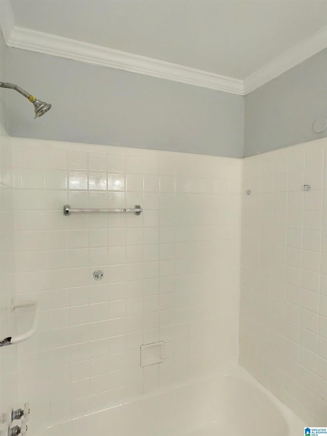 bathroom featuring ornamental molding and tiled shower / bath