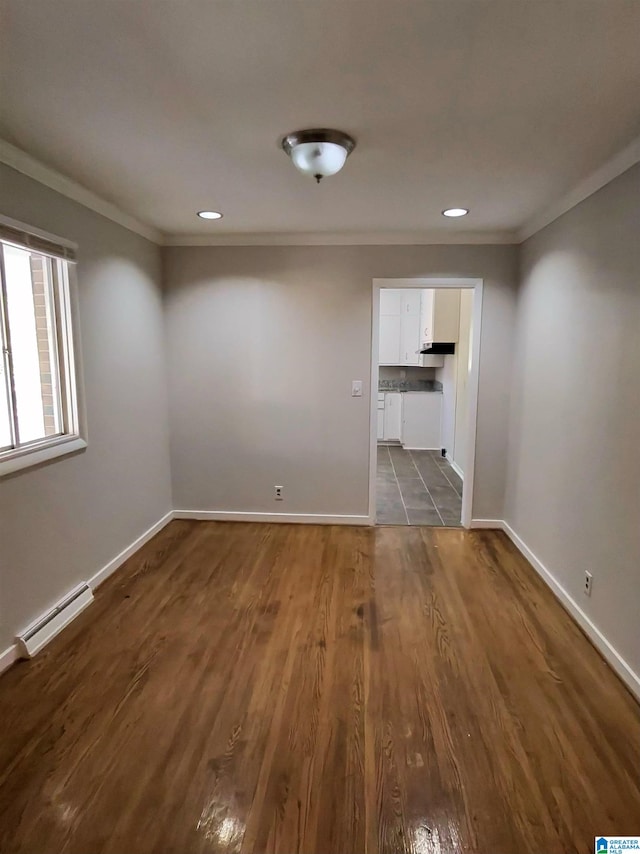 empty room with crown molding, dark hardwood / wood-style floors, and baseboard heating