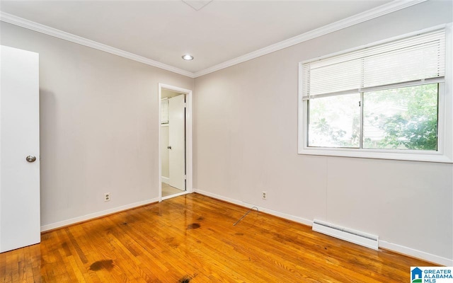 spare room featuring hardwood / wood-style flooring, ornamental molding, and a baseboard radiator