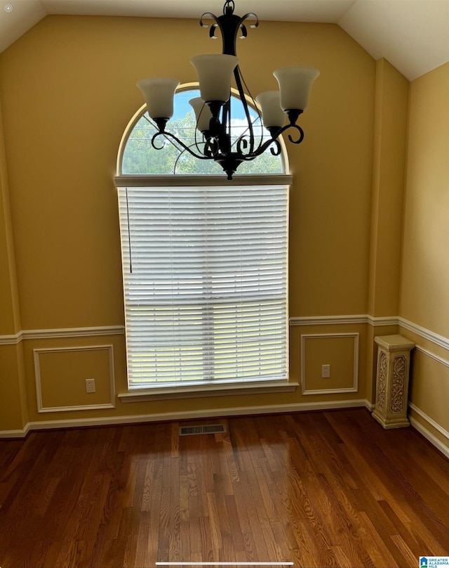 unfurnished dining area featuring lofted ceiling, dark hardwood / wood-style floors, and a notable chandelier