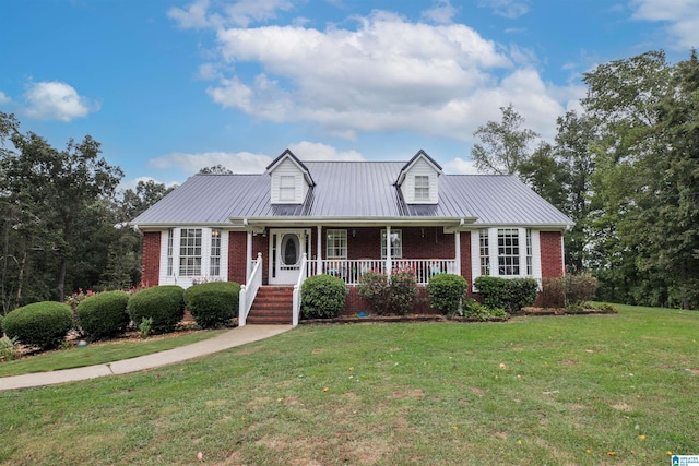 cape cod home featuring a porch, metal roof, brick siding, and a front lawn