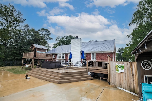 rear view of property featuring a patio and a deck