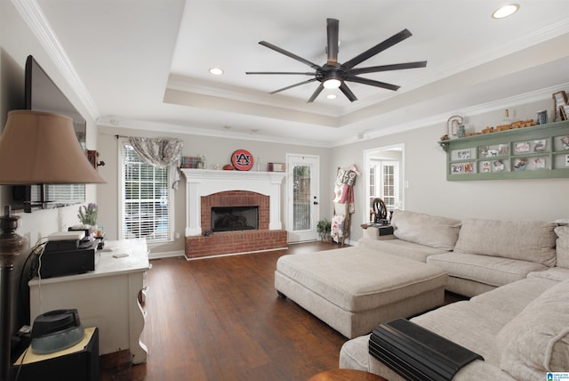 living room featuring ornamental molding, a brick fireplace, ceiling fan, and dark hardwood / wood-style flooring