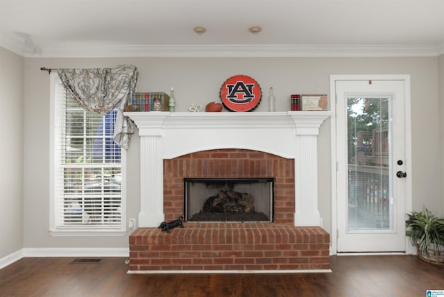 interior details featuring ornamental molding, hardwood / wood-style floors, and a brick fireplace