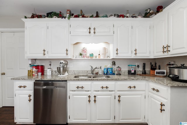 kitchen with dishwasher, white cabinetry, and sink