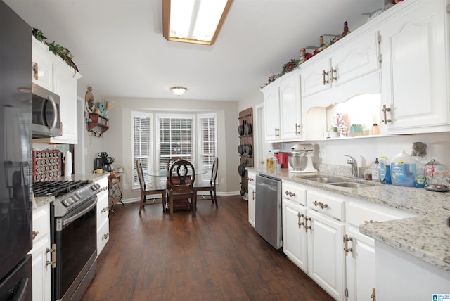 kitchen featuring light stone counters, white cabinets, sink, appliances with stainless steel finishes, and dark hardwood / wood-style floors