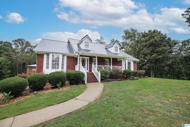 cape cod home with metal roof, brick siding, covered porch, and a front yard