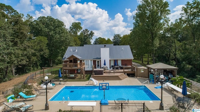 view of pool featuring a deck, a water slide, and a patio area