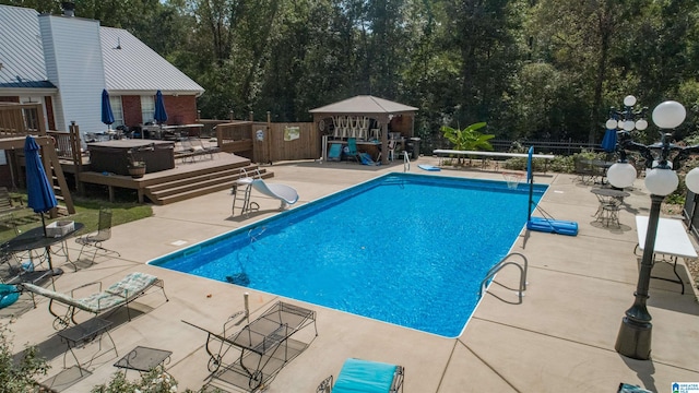 view of pool with a wooden deck, a patio, and a gazebo