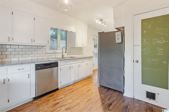 kitchen featuring white cabinets, light hardwood / wood-style flooring, light stone counters, stainless steel appliances, and sink