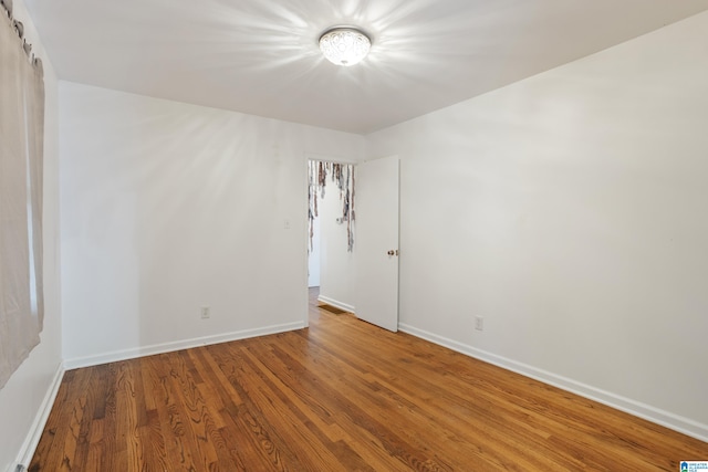 empty room with hardwood / wood-style flooring