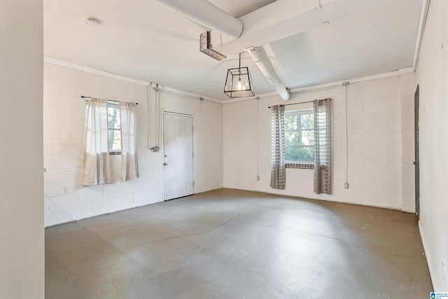 empty room featuring concrete floors and ornamental molding