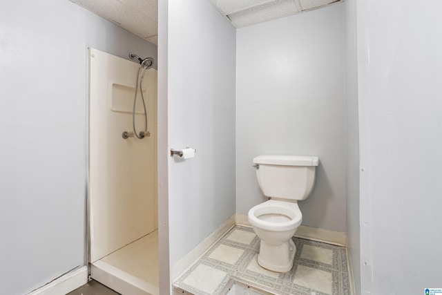 bathroom featuring a paneled ceiling, toilet, and walk in shower