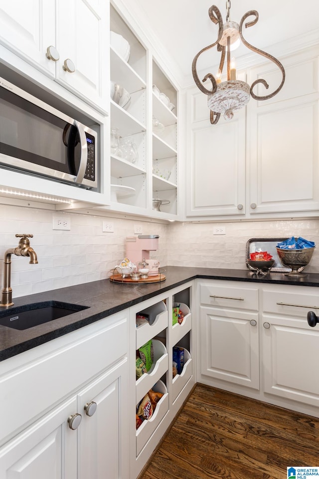 kitchen with ornamental molding, backsplash, sink, dark wood-type flooring, and white cabinets